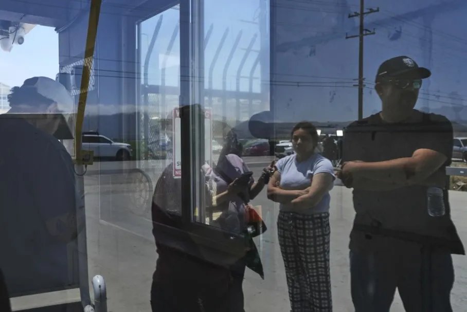 Personas esperan afuera de Glass House Farms, un día después de una redada de inmigración en las instalaciones, el viernes 11 de julio de 2025, en Camarillo, California. (Foto AP/Jae C. Hong)