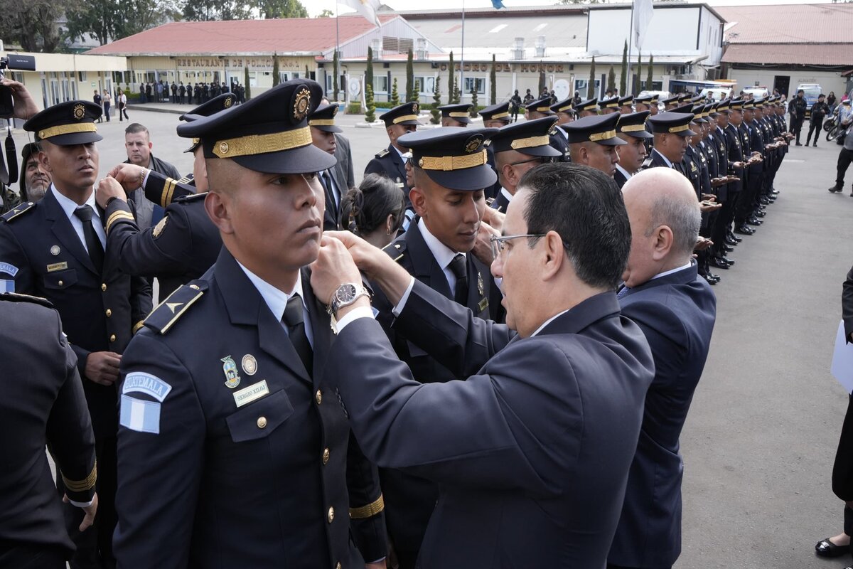 El ministro de Gobernación, Marco Antonio Villeda, coloca insignias en la graduación de los nuevos oficiales terceros de la Policía Nacional Civil. Foto: Ministerio de Gobernación