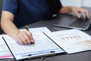 Persona revisa cuentas y cálculos relacionados con obligaciones tributarias y el IVA.